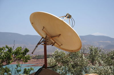 Traditional windmill against mountain range against clear sky