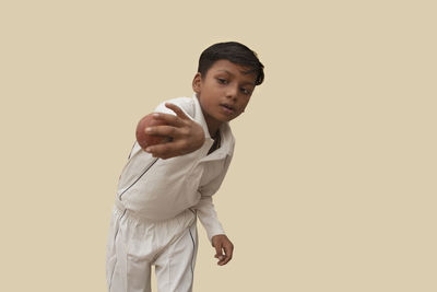 Portrait of young man standing against white background