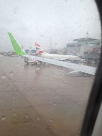 Airplane on airport runway against sky