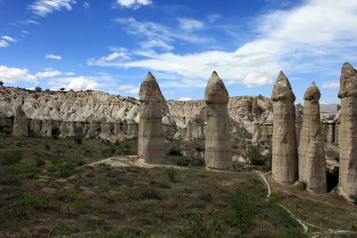 Ruins of rock formations against cloudy sky