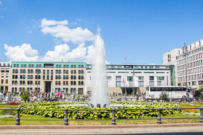 Fountain in city against sky