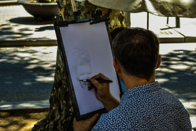 Rear view of man drawing
