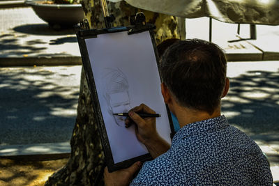 Rear view of man using mobile phone