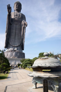 Statue of buddha against cloudy sky