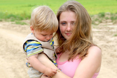 Portrait of mother and son standing at park