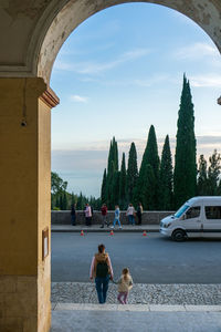Man with dog on street against sky