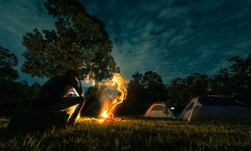 Bonfire on field against sky at night