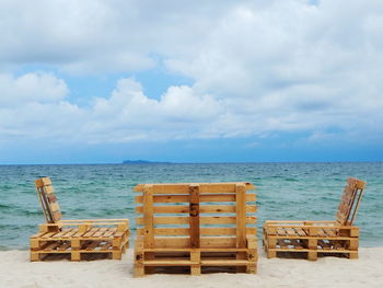 Chairs on beach against sky