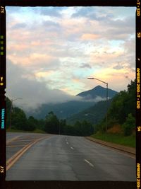 Empty road against cloudy sky