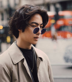 Portrait of young man wearing sunglasses standing outdoors