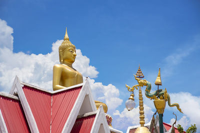 Low angle view of statue against building against sky