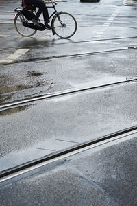 Low section of person riding bicycle on road