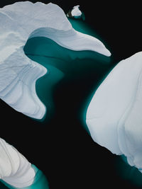 Low section of people relaxing on black background