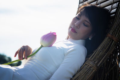 Portrait of woman with pink flowers against blurred background