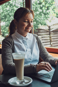 Smiling businesswoman working while sitting at cafe