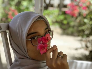 Close-up portrait of woman holding flowers