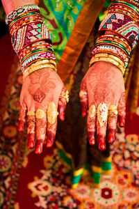 Midsection of woman with henna tattoo and jewelry