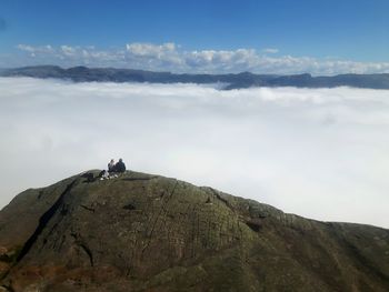 Low angle view of couple on mountain against sky