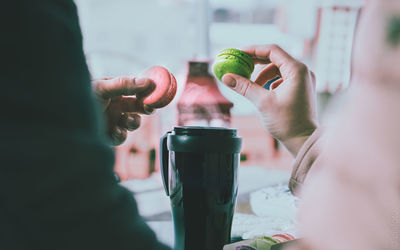 Close-up of hand holding drink on table