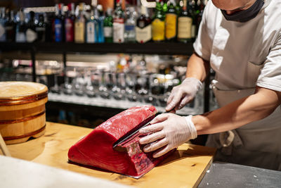 Male chef cutting large fish in kitchen at restaurant