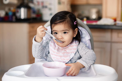 Cute girl eating food at home