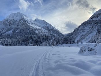 Scenic view of snow covered mountains against sky