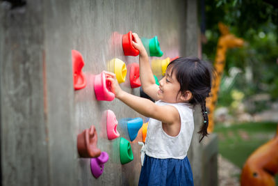 Girl playing with toy against wall