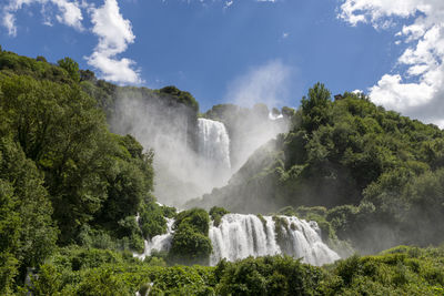 Scenic view of waterfall against sky