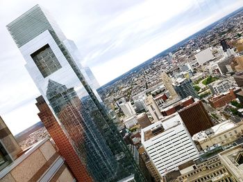 Aerial view of buildings in city against sky