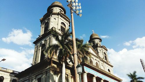 Low angle view of floodlights and cathedral against sky