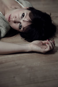 Close-up portrait of young woman lying down at home