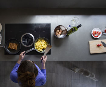 Overhead view of a woman cooking breakfast on the stove