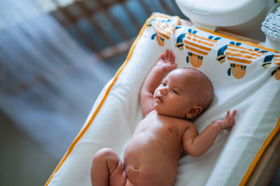 High angle view of baby boy lying on bed at home