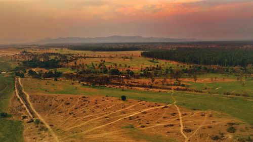 Scenic view of agricultural field against sky during sunset