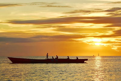 Silhouette boat in sea against sky during sunset