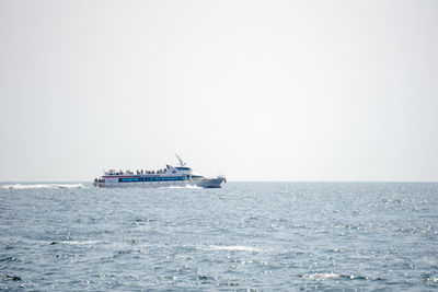 Ship sailing in sea against clear sky