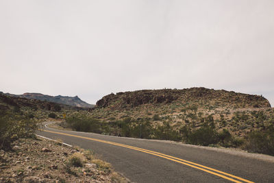 Road by mountain against clear sky