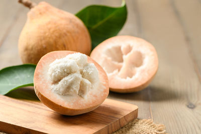 Half santol on wood background, santol has sour taste and the middle of santol is sweet