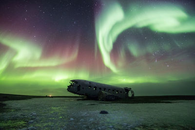 Abandoned airplane against sky at night