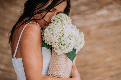 Midsection of woman holding flower bouquet