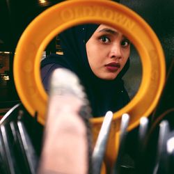 Portrait of young woman looking in mirror