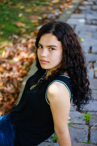 Portrait of beautiful woman standing against tree