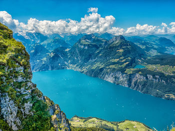 Panoramic view of sea and mountains against blue sky