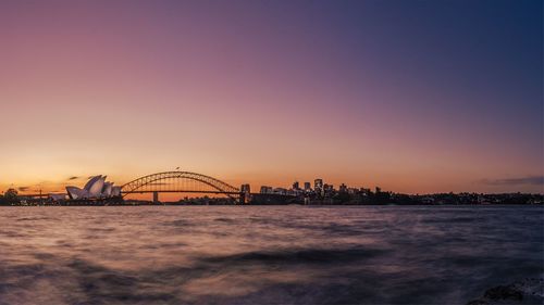 View of bridge over sea against sunset sky