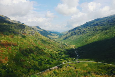 Scenic view of mountain range against cloudy sky
