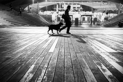 Man with dog walking on wooden floor