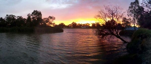 Scenic view of river against sky at sunset