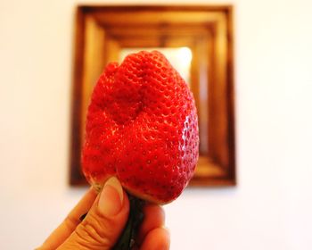 Close-up of hand holding strawberry