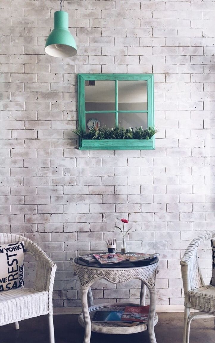 EMPTY CHAIRS AND TABLE AGAINST WALL AT HOME