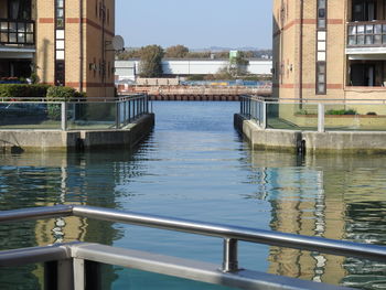 Bridge over canal by buildings in city